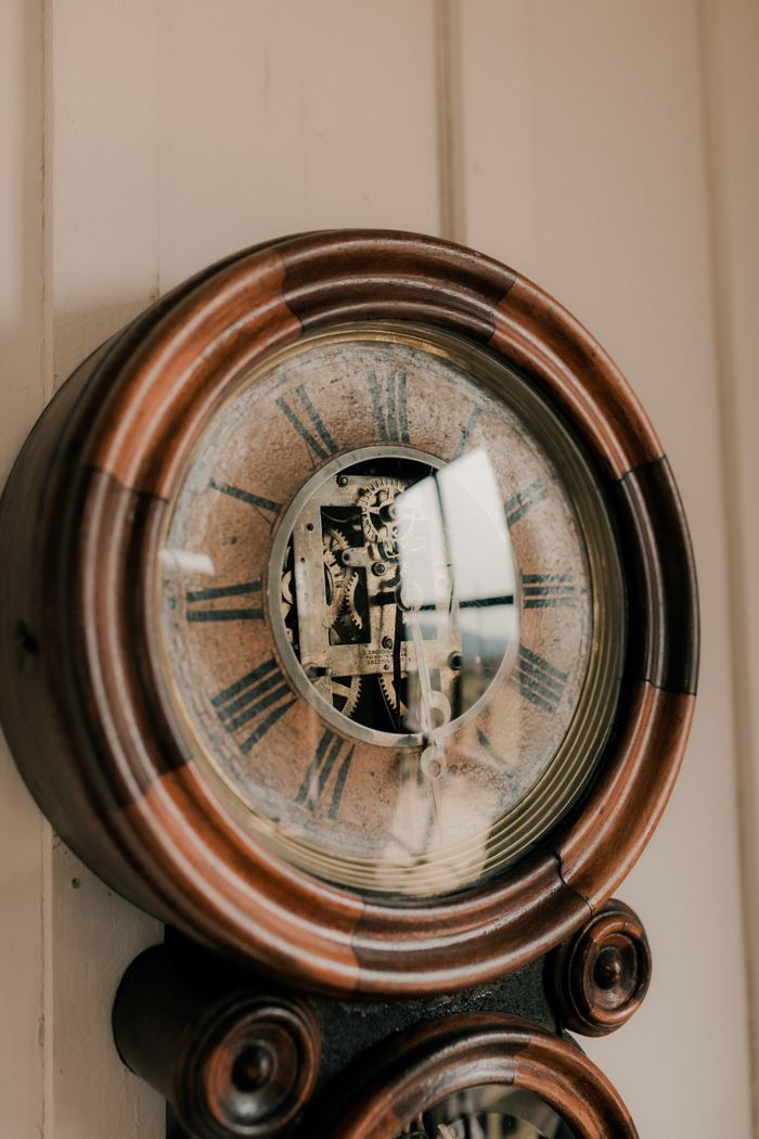 Close-up of an antique wooden clock showcasing intricate internal mechanisms.