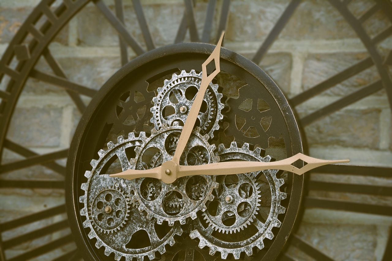 Close-up of a rustic wall clock with visible gears, exuding an antique charm.